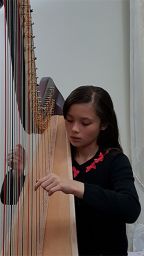 Ava playing the harp