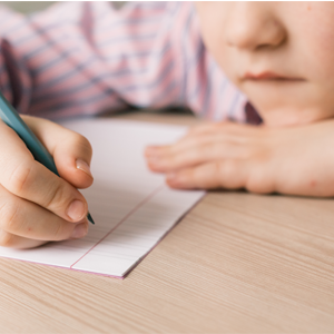 child beginning to write something on paper