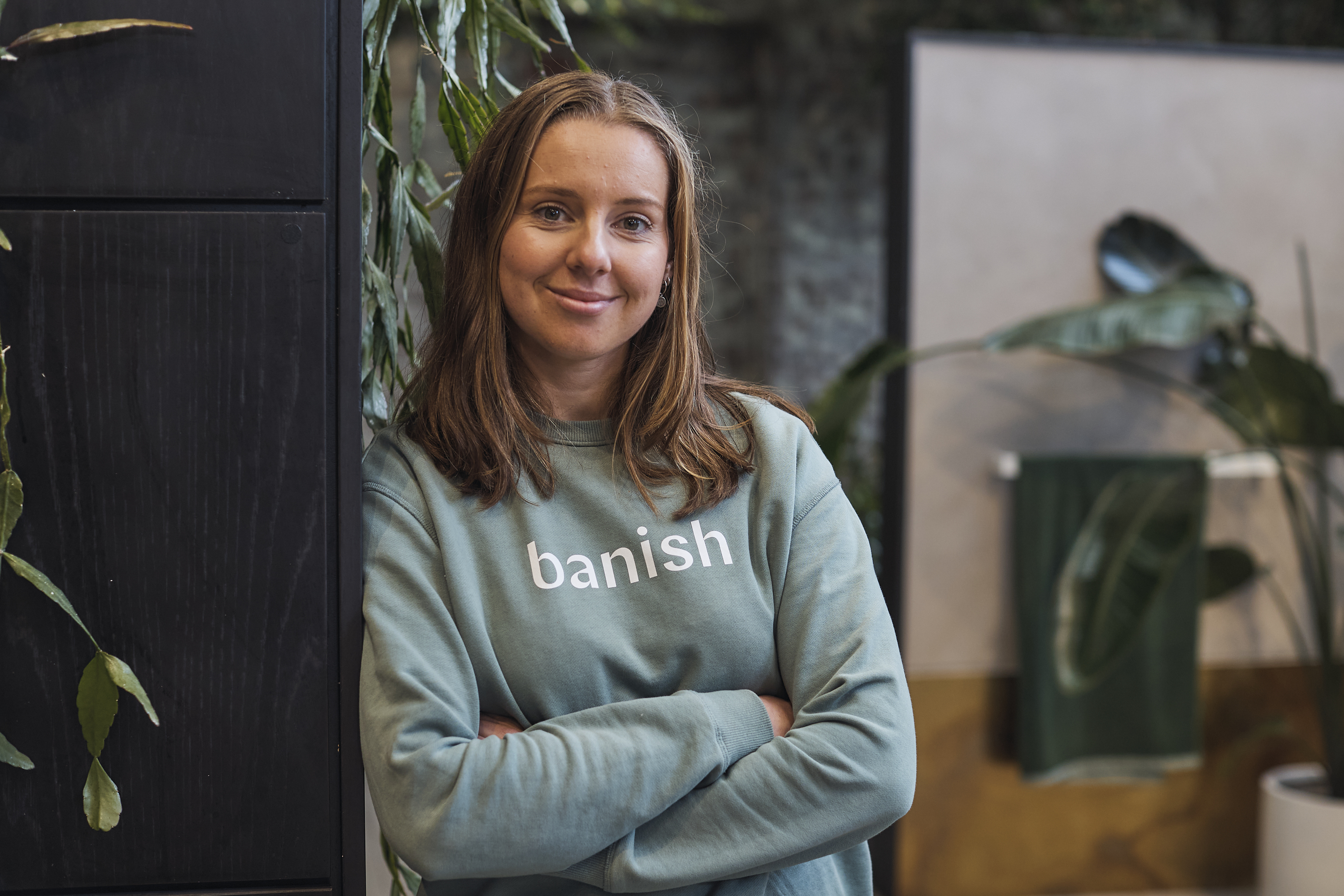 Lottie standing next to wall, wearing top with Banish written on it