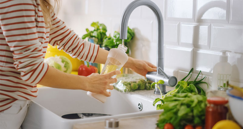 filling water bottle up in kitchen