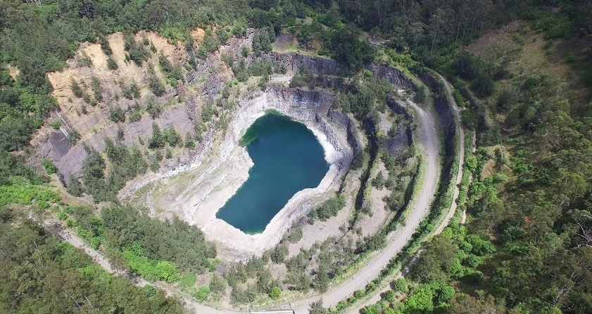 aerial shot of dam surrrounded by bushland