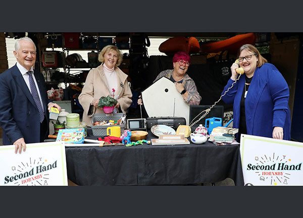 group in front of table with items on display