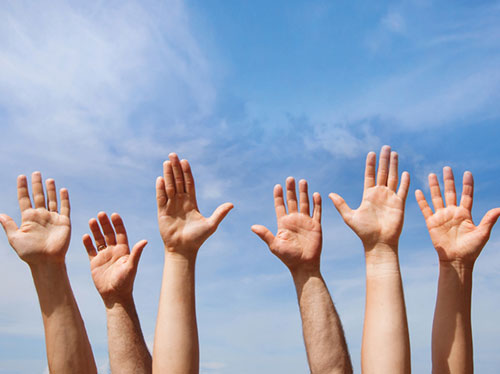 hands in the air with blue sky background