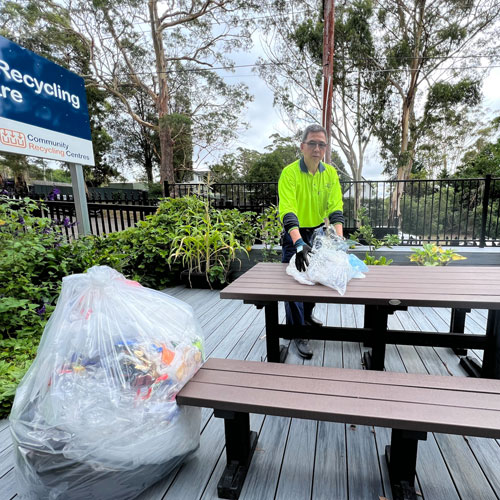 Community Recycling Centre Supervisor, Nathan Chen, in the CRC garden which is furnished with a table, benches and decking made from recycled products.