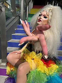 teen drag queen in full rainbow costume