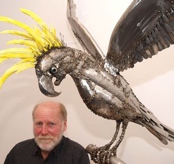 Ulric Steiner sitting beside bird steel sculpture