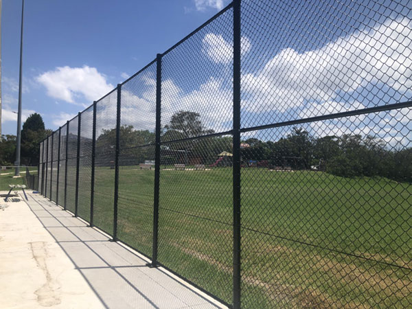 concrete path and steel fence next to field
