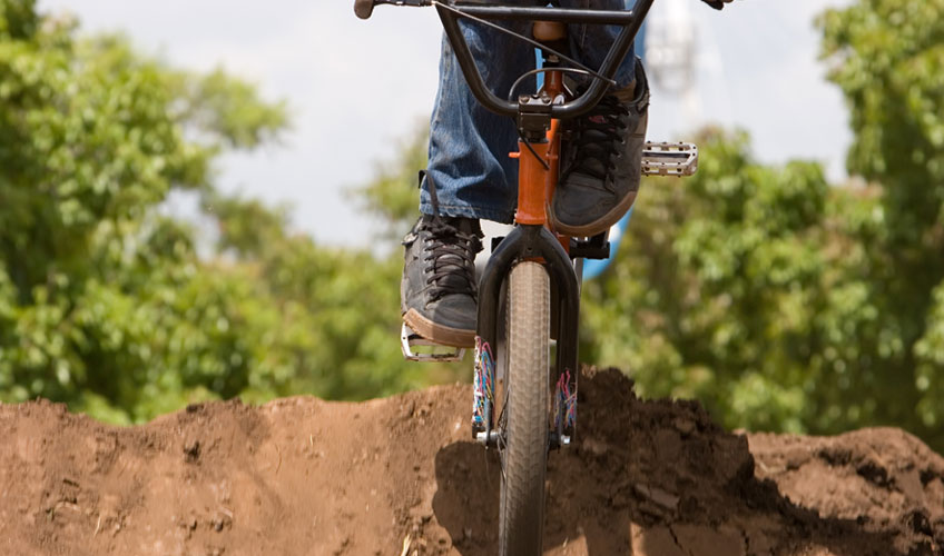 BMX rider jumping over dirt