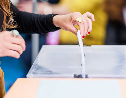hand putting paper in voting box