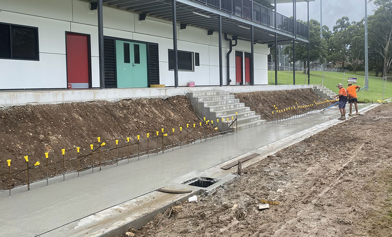 building with steps and path and 2 workers