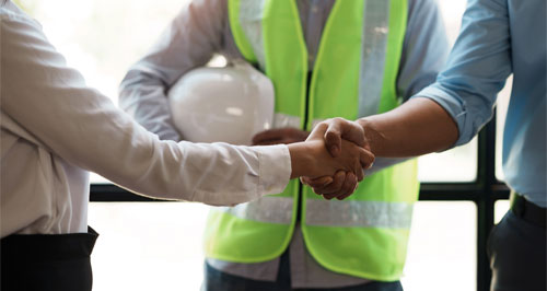 men shaking hands over construction paper