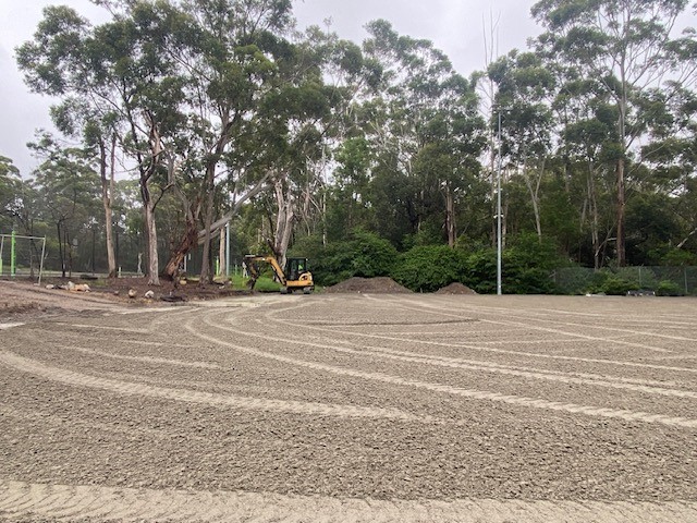 levelled soiled ground with digger in background