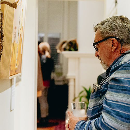 man staring at artwork on wall