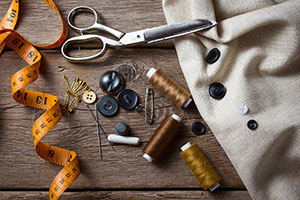 scissors, thread and tape measure on table