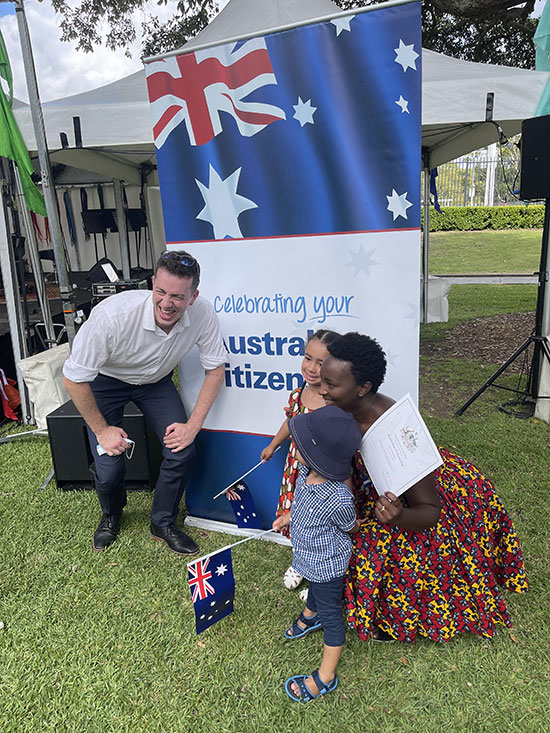 People in front of Australia Day citizenship poster