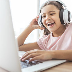 young girl with headphones on laptop