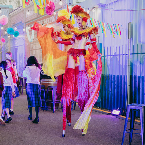 street performers in stilts with crowd nearby