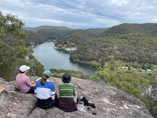 group sitting on rocks overlooking river