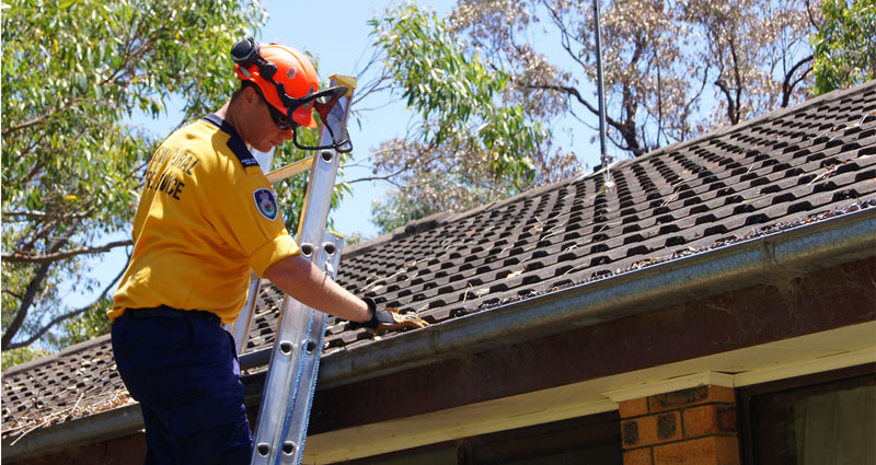 fireman cleaning out roof gutters